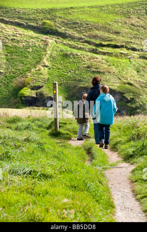 Un gruppo di famiglia a piedi lungo la costa sud occidentale il percorso nei pressi di Trebarwith Strand in Cornovaglia, England, Regno Unito Foto Stock