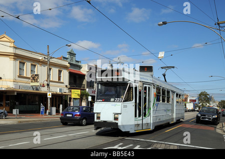 Il tram che passa suburbana alcuni negozi con facciate vittoriane Lygon Street Carlton Melbourne Australia Foto Stock