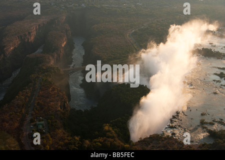Vista aerea di misty Victoria Falls una delle 7 meraviglie naturali del mondo e il ponte al confine con lo Zambia e Zimbabwe Foto Stock