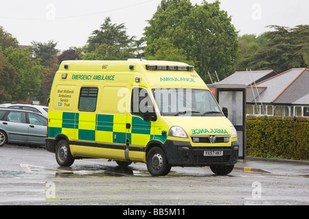NHS ambulanza di emergenza su strada in condizioni piovose Foto Stock