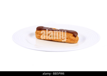 Un unico cioccolato Eclair su una piastra contro uno sfondo bianco Foto Stock