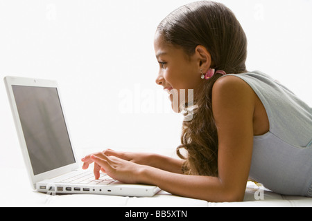 Razza mista ragazza utilizzando laptop Foto Stock