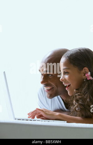 Razza mista padre e figlia utilizzando laptop Foto Stock