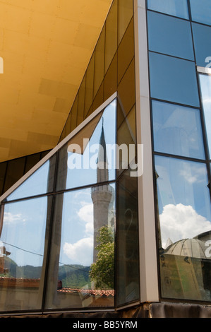 Un minareto della moschea è riflessa in una vetrata edificio moderno a Sarajevo capitale della Bosnia ed Erzegovina Foto Stock