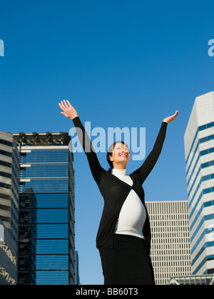 Medio incinta donna orientale con le braccia sollevate all'aperto Foto Stock