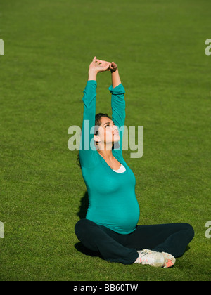 Medio incinta donna orientale a praticare yoga in posizione di parcheggio Foto Stock