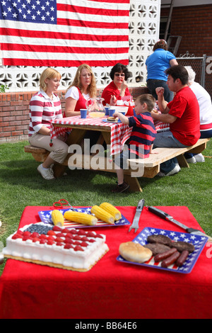 Tabella di cibo in primo piano con persone mangiare in background Foto Stock