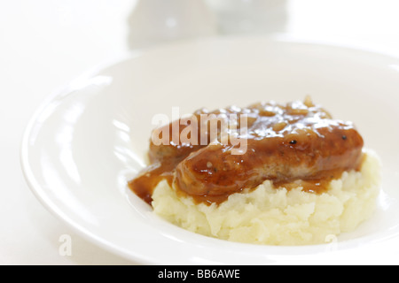 Fresche salsicce di maiale con purè di patate servita su una piastra bianca con n. di persone Foto Stock