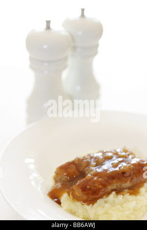 Fresche salsicce di maiale con purè di patate servita su una piastra bianca con n. di persone Foto Stock