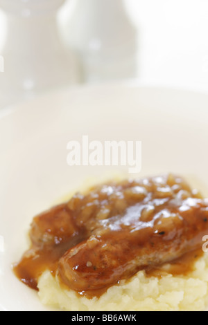 Fresche salsicce di maiale con purè di patate servita su una piastra bianca con n. di persone Foto Stock