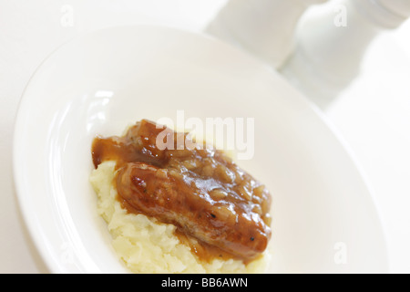 Fresche salsicce di maiale con purè di patate servita su una piastra bianca con n. di persone Foto Stock