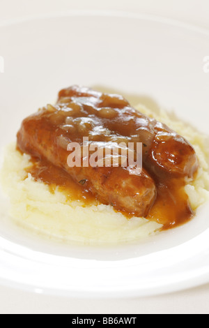 Fresche salsicce di maiale con purè di patate servita su una piastra bianca con n. di persone Foto Stock