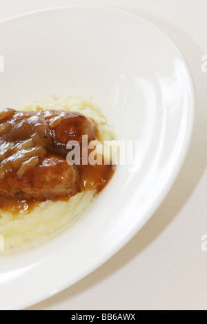 Fresche salsicce di maiale con purè di patate servita su una piastra bianca con n. di persone Foto Stock