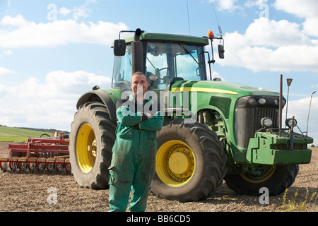 Conducente in piedi nella parte anteriore del trattore Foto Stock