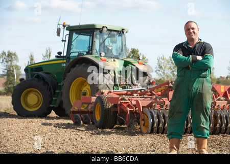 Conducente in piedi nella parte anteriore del trattore Foto Stock