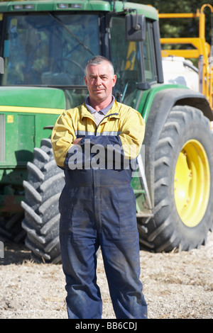 Conducente in piedi nella parte anteriore del trattore Foto Stock