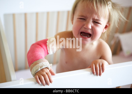 Il pianto dei bimbi con il braccio in Cast Foto Stock