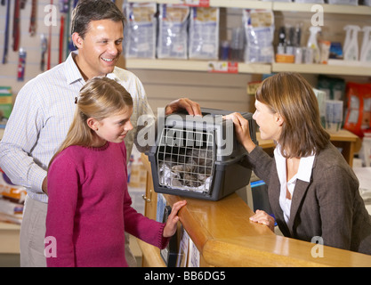 Ragazza e Padre tenendo Cat per esame da Vet Foto Stock