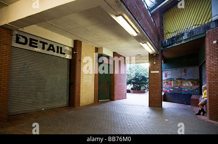 Ragazza nel moderno complesso di shopping con negozi chiusi e finestre con persiane Galles Swansea Regno Unito Foto Stock