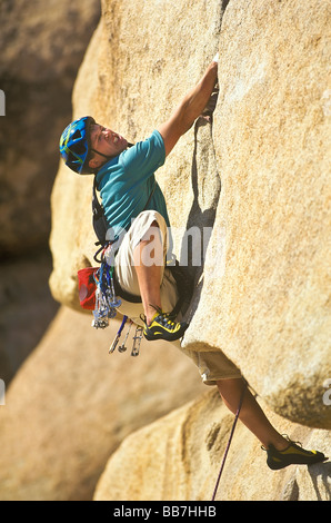 Scalatore risale una ripida roccia sbalzo. Foto Stock
