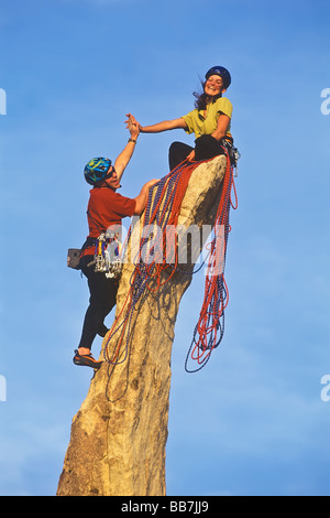 Un gruppo di alpinisti salire una ripida roccia. Foto Stock