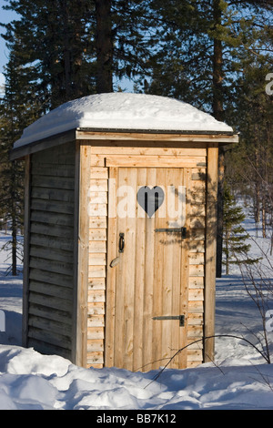 Coperte di neve toilette in una foresta wintery in Kiruna, nel nord della Svezia, Svezia Foto Stock