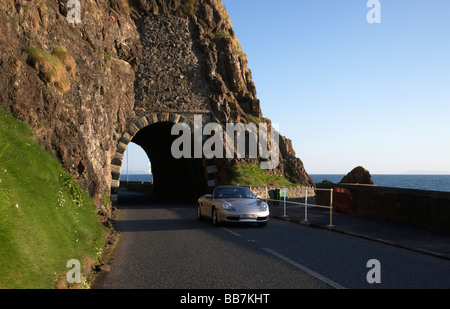 Porsche auto sulla A2 causeway percorso costiero coast road passa attraverso il passaruota neri al di fuori di Larne Foto Stock