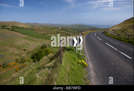 Curva pericolosa paese sulla strada di montagna anche se glenballyemon strada panoramica valle di glen County Antrim Irlanda del Nord Regno Unito Foto Stock