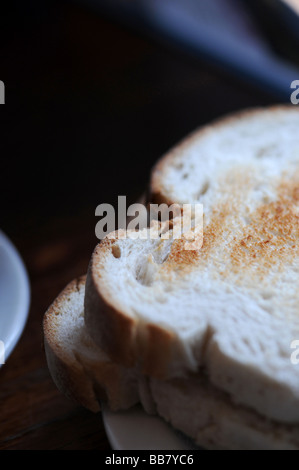 Due fette di pane abbrustolito fetta di pane come parte di una prima colazione pasto, fotografato in una caffetteria locale Foto Stock