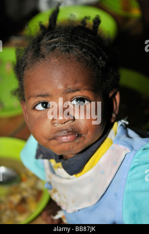 Piccolo, scuro spellate, cross-eyed girl in una zuppa di cucina, baraccopoli di Alto de Cazuca, Soacha, Bogotá, Colombia Foto Stock