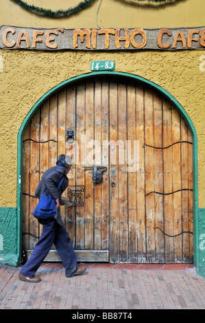 Uomo anziano davanti a un passato coloniale cancello in legno, La Candelaria distretto, a Bogotá, Colombia, Sud America Foto Stock