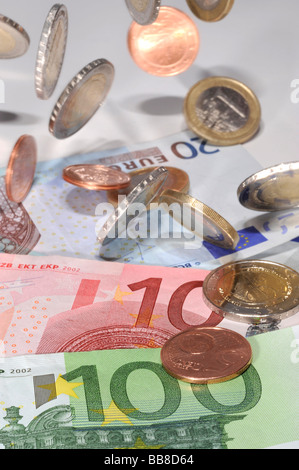 Le banconote e le monete in euro, immagine simbolica per la pioggia di denaro Foto Stock