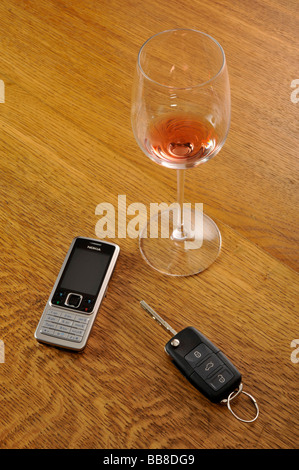 Svuotare un bicchiere di vino rosso, le chiavi dell'auto, simbolica della guida in stato di ebbrezza Foto Stock