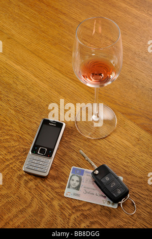 Svuotare un bicchiere di vino, chiavi auto, simbolica della guida in stato di ebbrezza Foto Stock