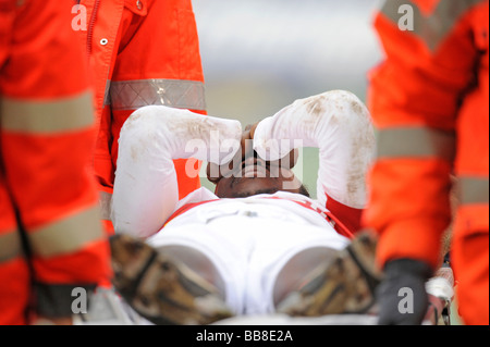 Arthur Boka, giocatore di calcio VfB Stuttgart, essendo portati dal campo su una barella da personale paramedico Foto Stock