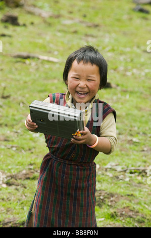 Ragazza giovane Yak-imbrancandosi famiglia. Gode di radio. Pele La Pass. ca. 11.000 piedi, Bhutan Foto Stock