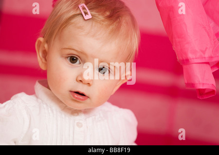 Ritratto di una giovane ragazza, 1 anni, nella parte anteriore di un giocattolo rosa tenda Foto Stock