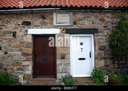 St Cuthberts pietra costruito Cottages sull Isola Santa Lindisfarne Nord Northumberland Coast Inghilterra REGNO UNITO Foto Stock