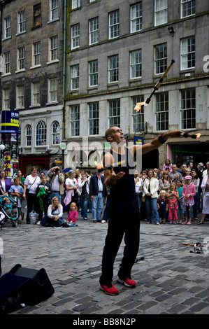 Street Performer intrattiene il pubblico di giocoleria torce di fuoco Edinburgh Fringe Festival Scozia UK Europa Foto Stock