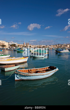 Tradizionali barche da pesca maltesi, chiamato Luzzu, di fronte alla chiesa della Madonna di Pompei, porto di Marsaxlokk, Malta, Euro Foto Stock