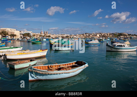 Tradizionali barche da pesca maltesi, chiamato Luzzu, di fronte alla chiesa della Madonna di Pompei, porto di Marsaxlokk, Malta, Euro Foto Stock