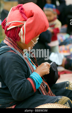 Rosso donna Hmong cucito un souvenir, SAPA, Vietnam Foto Stock