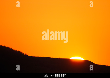 Sole che sorge su una collina Foto Stock