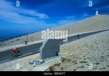 I ciclisti passano il monumento a Tom Simpson vicino alla vetta del Mont Ventoux Provence Francia Foto Stock