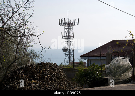 Un' antenna per le telecomunicazioni posizionata sopra le case Foto Stock