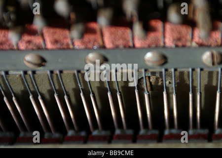 All'interno di un pianoforte verticale che mostra le stringhe di tensione gli smorzatori e feltro Foto Stock