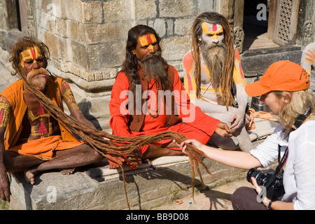 Un turista controlla la barba di un sadhu al tempio di Pashupatinath Foto Stock