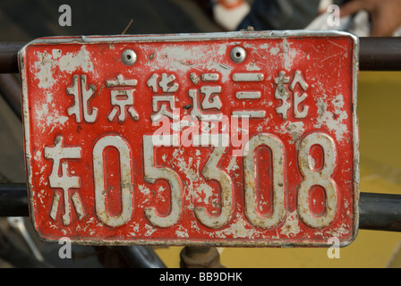 Close-up di un rosso rickshaw targa con il suo carattere obbligatorio "Jing' per Pechino, Repubblica Popolare Cinese. Foto Stock