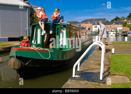 Barca stretta con tre ragazze in giubbotti di salvataggio, di entrare nel blocco del canale a bacinella Diglis, Worcester, Regno Unito. Canal Boat UK. Foto Stock