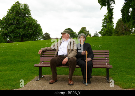 Anziana coppia sposata seduta su una panchina nel parco Foto Stock